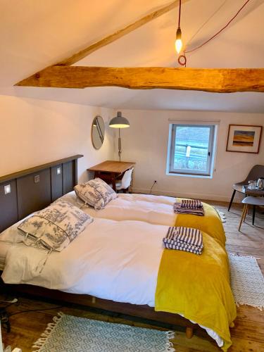 a bedroom with a large bed in a room at La Rive Chambre d hôtes The Riverside Retreat in Jarnac