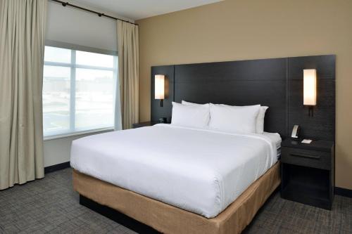 a bedroom with a large bed and a large window at Residence Inn by Marriott St Louis Chesterfield in Chesterfield