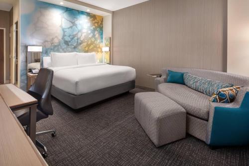 a hotel room with a bed and a couch at Courtyard by Marriott Petaluma Sonoma County in Petaluma