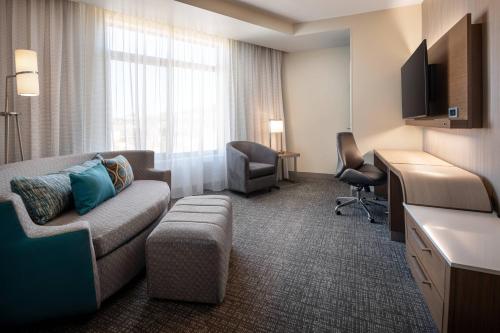 a hotel room with a couch and a desk at Courtyard by Marriott Petaluma Sonoma County in Petaluma