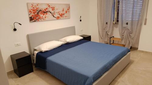 een slaapkamer met een blauw bed met 2 kussens bij Neapolis Apartment & Rooms in Siracusa