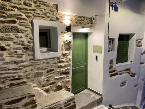 a room with a green door and a stone wall at Dryopis Studio in Dhriopís