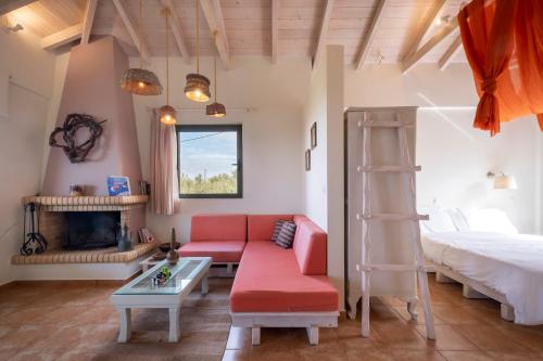 ein Wohnzimmer mit einem roten Sofa und einem Bett in der Unterkunft Chamaloni Cottages in Finikounda