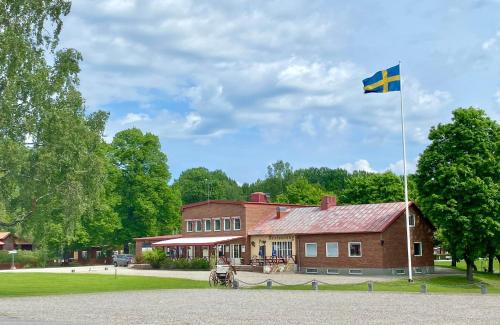 eine Flagge auf einer Stange vor einem Gebäude in der Unterkunft Brevensgården 