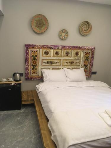 a bedroom with a large white bed with a headboard at By Muhtar Hotel Bodrum in Bodrum City