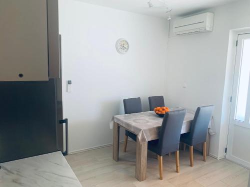 a dining room with a table and blue chairs at Jerkovic Apartment in Žuljana