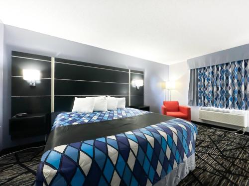 a hotel room with a bed and a red chair at Blaine Town Inn & Suites in Blaine