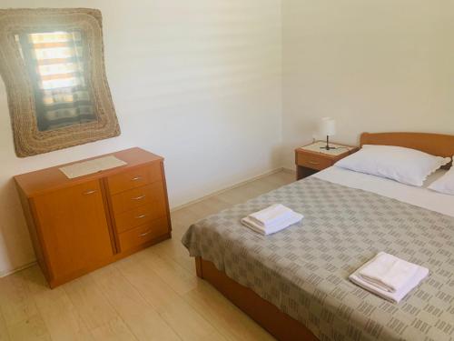a bedroom with a bed and a dresser and a mirror at Jerkovic Apartment in Žuljana
