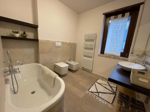 ein Badezimmer mit einer Badewanne, einem WC und einem Waschbecken in der Unterkunft Casa Volver in Riva del Garda