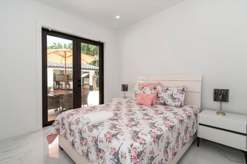 a white bedroom with a bed and a window at The tropical paradise villa in Miami