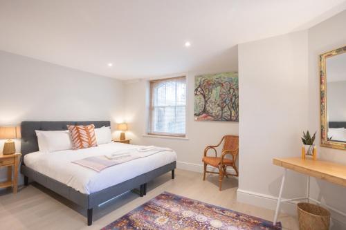 una camera con letto e specchio di Spacious 2BR Victorian Cheltenham flat in Cotswolds Sleeps 6 - FREE Parking a Cheltenham