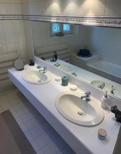 une salle de bain avec deux lavabos et un grand miroir dans l'établissement Bastide Sainte Marie, à Mallemort