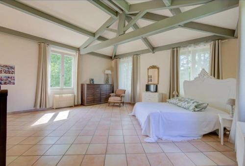 une chambre avec un grand lit blanc et des fenêtres dans l'établissement Bastide Sainte Marie, à Mallemort