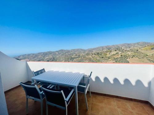 d'une table et de chaises sur un balcon avec vue. dans l'établissement Ático con increíbles vistas a las montañas y mar, à Frigiliana