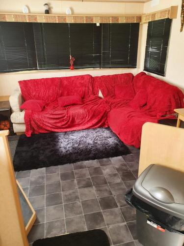 a red couch sitting in a living room at R and B static Caravan in Skegness
