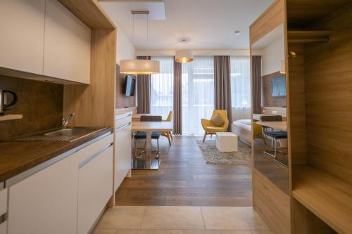 a kitchen with white cabinets and a living room at PM-PremiumAPART Strassgang in Graz