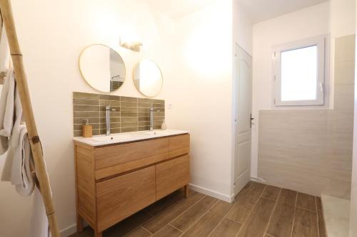 baño con lavabo y 2 espejos en la pared en Bastide Magnolia - Les dépendances, Roussillon, en Roussillon