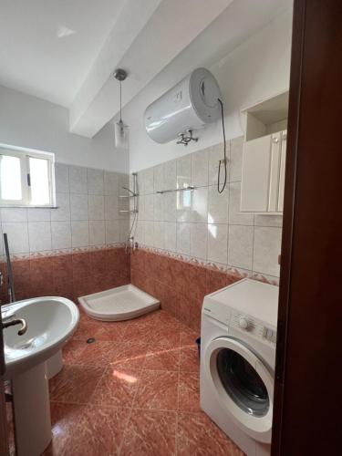 une salle de bain avec une machine à laver et un lavabo dans l'établissement Vivo Apartment, à Durrës