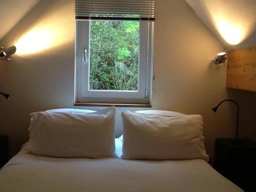 a bedroom with a bed with two pillows and a window at Blar na Leisg, Self catering Lodge 2. in Drumbeg