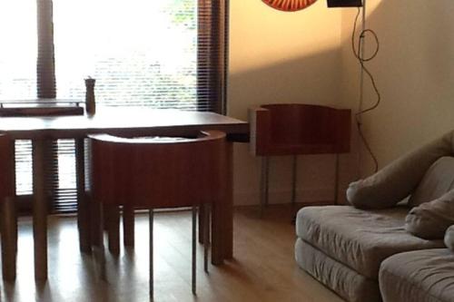 un soggiorno con tavolo, sedie e divano di Blar na Leisg, Self catering Lodge 2. a Drumbeg