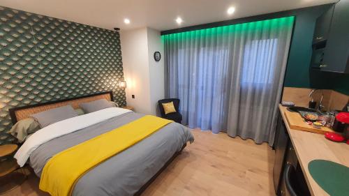 sypialnia z dużym łóżkiem z żółtym i białym kocem w obiekcie Studio L'élégance Place de Jaude et garage w mieście Clermont-Ferrand