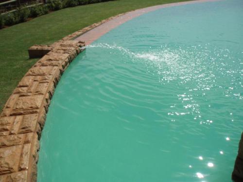 una gran piscina de agua con una pared de piedra en F19 Ocean View Villas, en Port Edward