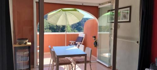 - une salle à manger avec une table et un parasol dans l'établissement Résidence les rivages de la coudouliere, à Six-Fours-les-Plages