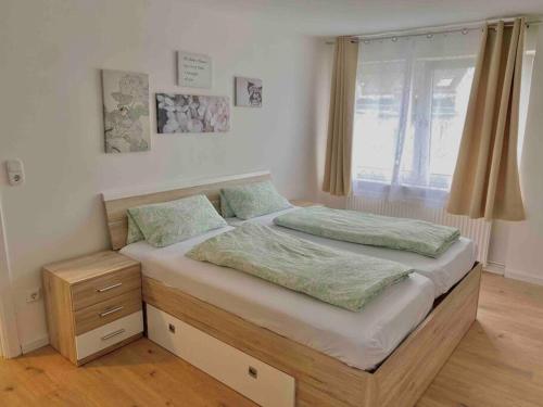 een slaapkamer met een groot bed en een raam bij Citynahe 2-Zimmer Wohnung in Lübeck