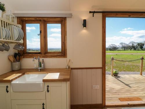 a kitchen with a sink and a view of a field at Buzzards in Crediton