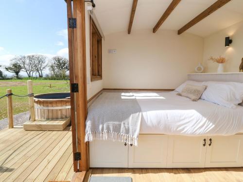 a bedroom with a bed on a deck at Buzzards in Crediton