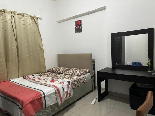 a bedroom with a bed and a desk and a television at JP Apartment in Dubai