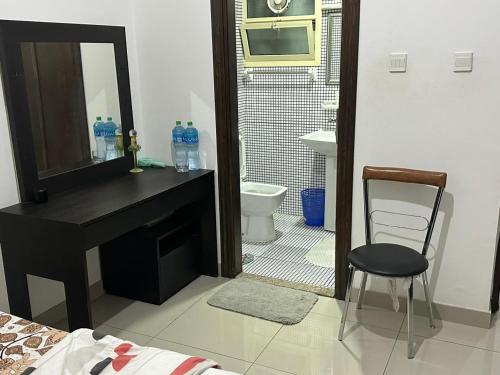 a bathroom with a sink and a mirror and a chair at JP Apartment in Dubai