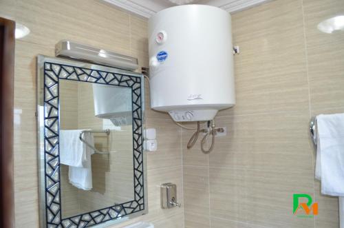 La salle de bains est pourvue d'un grand miroir et d'un lavabo. dans l'établissement RESIDENCES MICKEL, à Yaoundé
