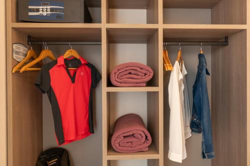 a walk in closet with clothes and a red shirt at Goloritzè Room and Breakfast in Baunei