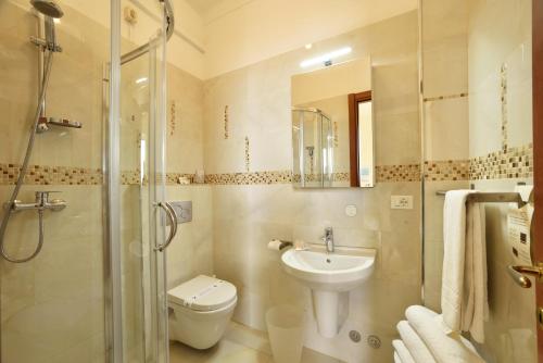 Hotel Villa Giulia في لايقويليا: حمام مع مرحاض ومغسلة ودش
