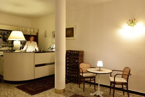 Hotel Villa Giulia في لايقويليا: امرأة تقف في مطبخ مع طاولة