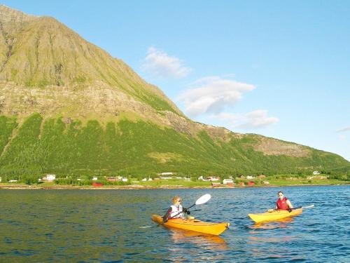two people in kayaks on a lake with a mountain at 6 person holiday home in Sandhornøy-By Traum in Røssnes
