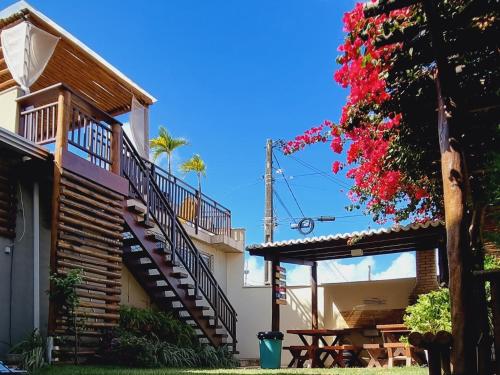 ein Haus mit einer Treppe, einem Tisch und Blumen in der Unterkunft Muriú Beach Flat in Muriú