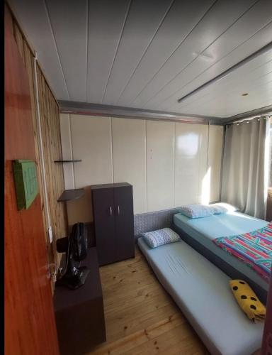 a small bedroom with a bed and a desk at Trip Adventure Hostel in Porto Belo
