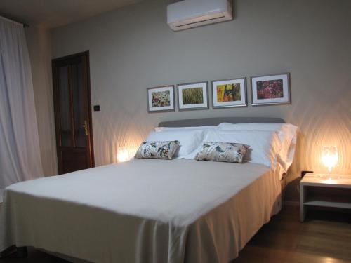 1 dormitorio con 1 cama blanca y 2 almohadas en Alla Torre - nel cuore del Borgo storico en Castagnole Lanze