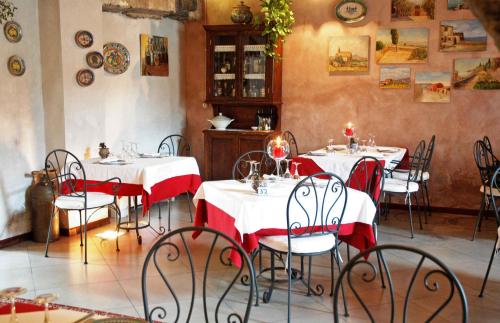 a restaurant with tables with red and white tablecloths at Etna Hotel in Giarre