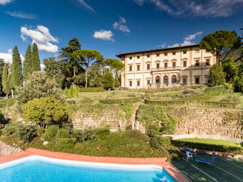 une image d'une maison avec une piscine en face de celle-ci dans l'établissement Villa Pitiana, à Donnini