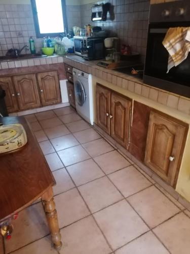 - une cuisine avec des placards en bois et un lave-vaisselle blanc dans l'établissement Villa provençale, à Aups