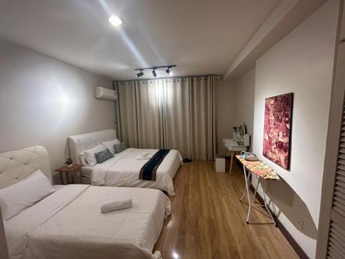 een hotelkamer met 2 bedden en een bank bij Newly Riverbank suites 408 in Kuching