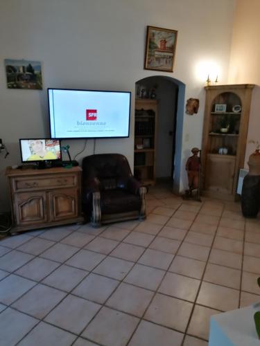 un salon avec une télévision à écran plat et une chaise dans l'établissement Villa provençale, à Aups