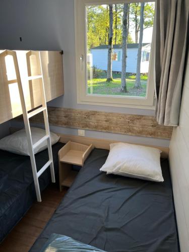 Ce lit se trouve dans un dortoir doté d'une fenêtre et d'une échelle. dans l'établissement Coeur de Vendee, à La Boissière-de-Montaigu
