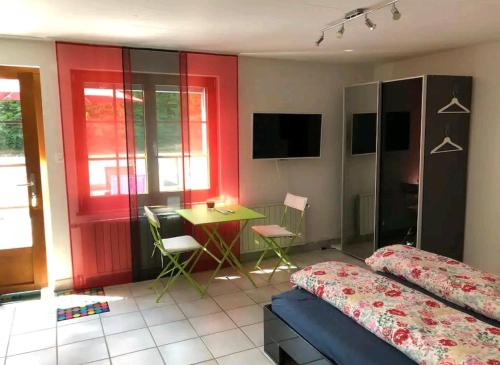 Zimmer mit 2 Betten, einem Tisch und einem Schreibtisch in der Unterkunft Studio à Courrendlin in Courrendlin