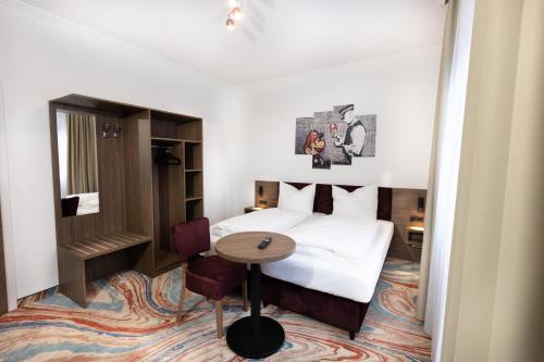 ein Hotelzimmer mit einem Bett und einem Tisch in der Unterkunft Firzlaff's Hotel in Neumünster