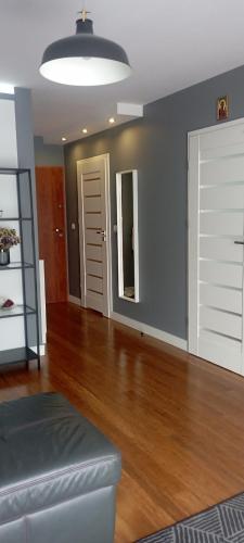 sala de estar con puerta blanca y suelo de madera en Apartament Komfort, en Zamość