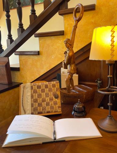 a book on a desk with a statue of a boy at Hotel Rural El Texeu in Llanes